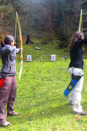 jeunes femmes tirant à l'arc sur des cibles en forme d'animaux dans la forêt