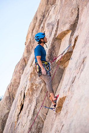 homme suspendu sur une falaise d'escalade