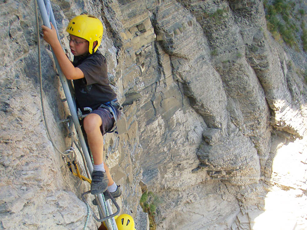 enfant montant une echelle en via ferrata